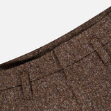 Close-up of the waistband of the BRUNELLO CUCINELLI Donegal Wool Barrel Pleated Pant, featuring prominent belt loops and highlighting the rich texture and weave of the brown tweed wool fabric in a classic barrel fit silhouette, set against a plain white background in signature Brunello Cucinelli style.