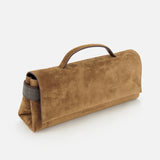 The Essence Suede Top Handle Clutch by BRUNELLO CUCINELLI is a brown suede roll-up bag featuring a handle, a gray strap on one end, and subtle embossed text near the bottom; expertly crafted in Italy and presented against a white background.