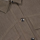 Close-up of the No Fade Indigo Cropped Jacket by BRUNELLO CUCINELLI, featuring part of the collar, three dark buttons, visible seams, two angled chest pockets, and detailed stitching on indigo denim fabric.