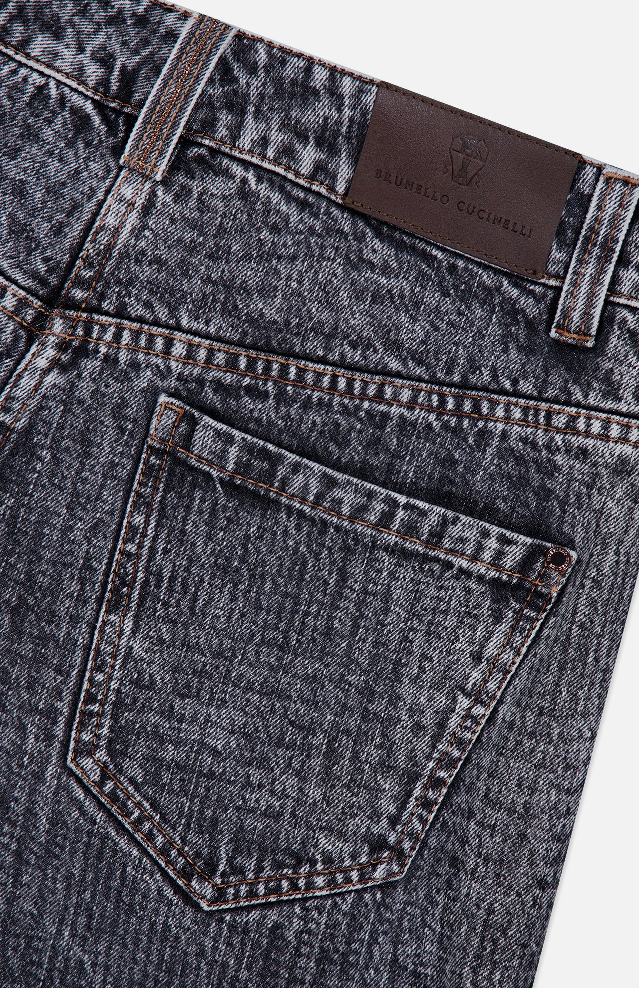 Close-up of the Prince Of Whales Embossed Wide Barrel Jean by BRUNELLO CUCINELLI, showcasing its dark blue barrel fit silhouette, a back pocket with brown stitching details, and a brown leather BRUNELLO CUCINELLI brand patch on the waistband.