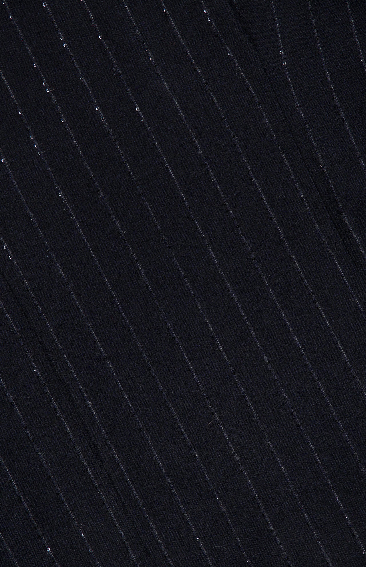 Close-up of the Sequin Pinstripe Wool Dress with Monili Collar by BRUNELLO CUCINELLI, featuring black wool fabric adorned with thin, evenly spaced diagonal silver pinstripes that create a subtle, shimmering effect—ideal for elevating tailored womenswear or highlighting the signature monili collar detail.