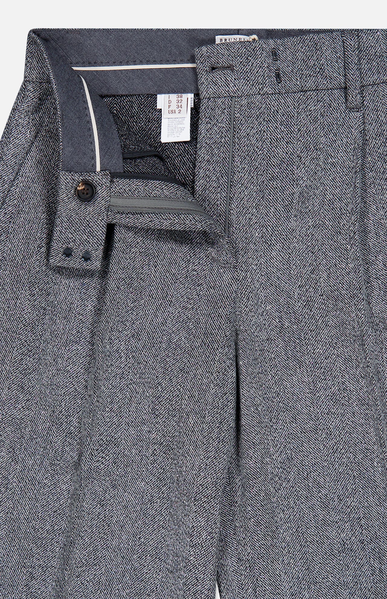 Close-up of the BRUNELLO CUCINELLI Sparkling Herringbone Loose Pleated Pant in silver-grey, featuring a classic herringbone pattern. The front button, zipper, and waistband are partially open to showcase the interior lining and brand label. Expertly crafted in Italy from fine wool.