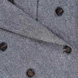 Close-up of the Sparkling Wool Herringbone Blazer by BRUNELLO CUCINELLI in a silver-grey shade, showcasing the textured wool fabric, sophisticated double-breasted button arrangement, contrasting black buttons, and refined lapels.