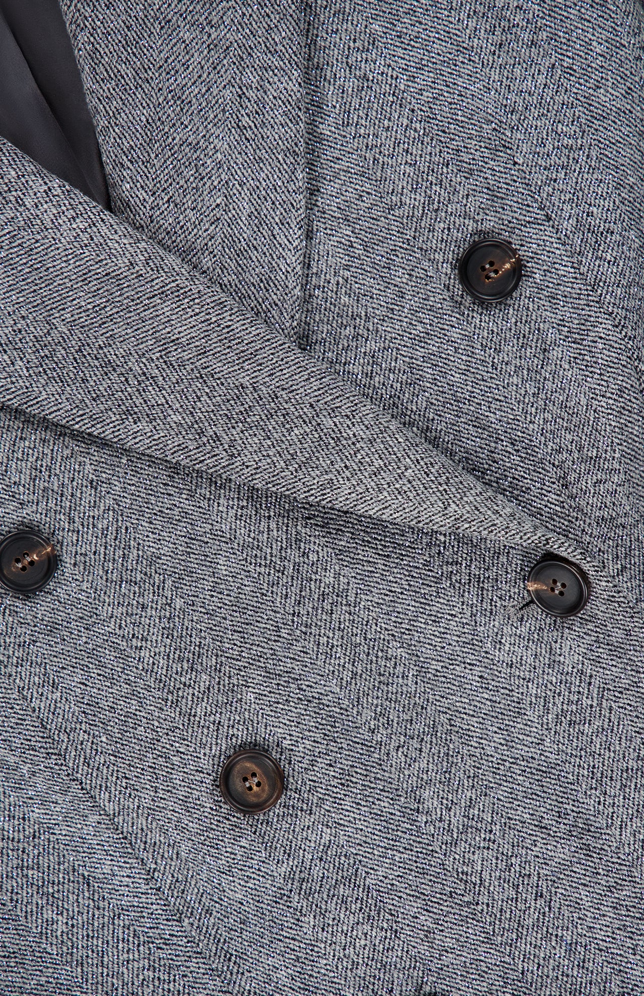 Close-up of the Sparkling Wool Herringbone Blazer by BRUNELLO CUCINELLI in a silver-grey shade, showcasing the textured wool fabric, sophisticated double-breasted button arrangement, contrasting black buttons, and refined lapels.