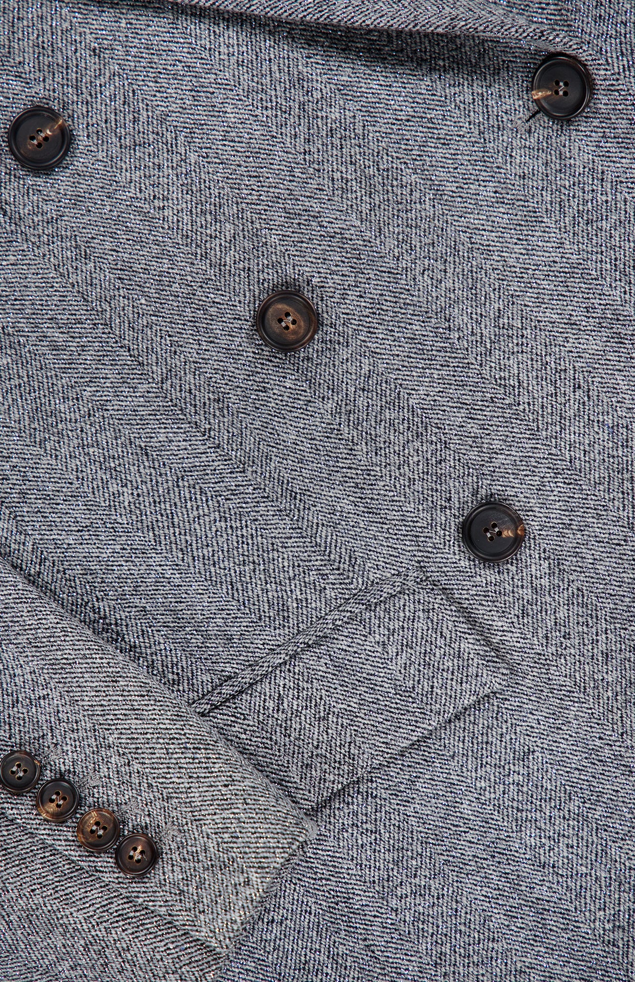 Close-up of the BRUNELLO CUCINELLI Sparkling Wool Herringbone Blazer in silver-grey, showing a lapel and part of the sleeve with four matching black buttons.