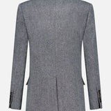 The Sparkling Wool Herringbone Blazer by BRUNELLO CUCINELLI is displayed from the back, showcasing its gray textured wool herringbone fabric, long sleeves, notched collar, two back seams, side vents, and cuff button details against a plain white background.