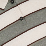 Close-up of the BRUNELLO CUCINELLI Wool Cashmere Knit Stripe Polo Top with horizontal gray and cream stripes, thin brown lines, a collar, and two dark brown buttons on the placket.