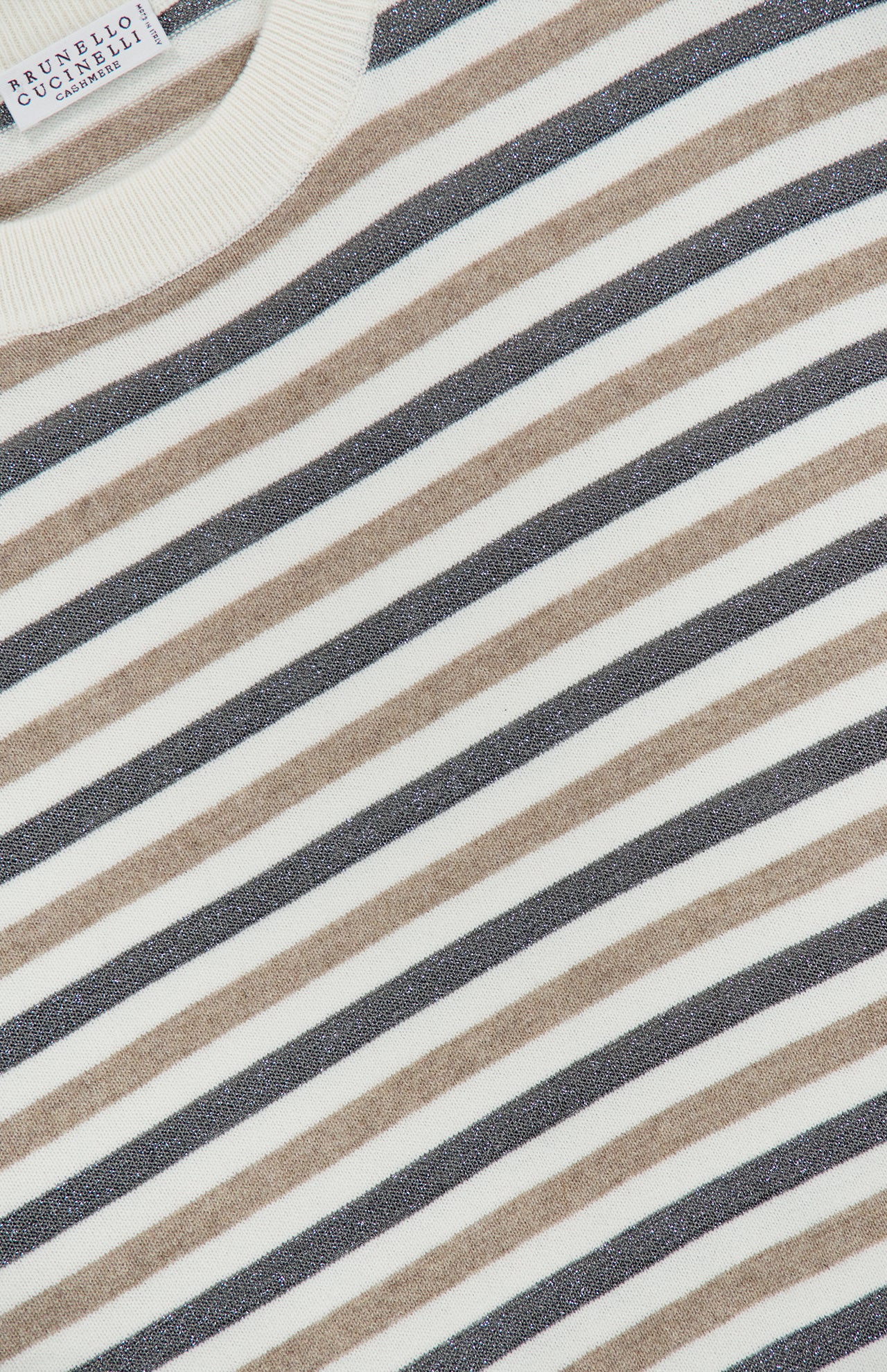 Close-up of the Wool Cashmere Striped Knit Sweater featuring horizontal beige, black, and white stripes. A white neckline and a fabric label reading BRUNELLO CUCINELLI are visible in the top left corner. This luxurious pullover is crafted in Italy from a wool-cashmere blend, exemplifying exquisite craftsmanship and timeless style.