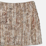 A close-up of a textured, woven beige and brown fabric with vertical rows of metallic and woolen threads, reminiscent of the exquisite craftsmanship found in the Wool Diamante Boucle Tweed Mini Skirt by BRUNELLO CUCINELLI.