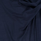Luxurious dark navy wool jersey by BRUNELLO CUCINELLI features a gentle drape and subtle sheen, with softly textured wrinkles that highlight the play of light and shadow—an ideal fabric for the sophisticated Wool Jersey Wrap Dress.