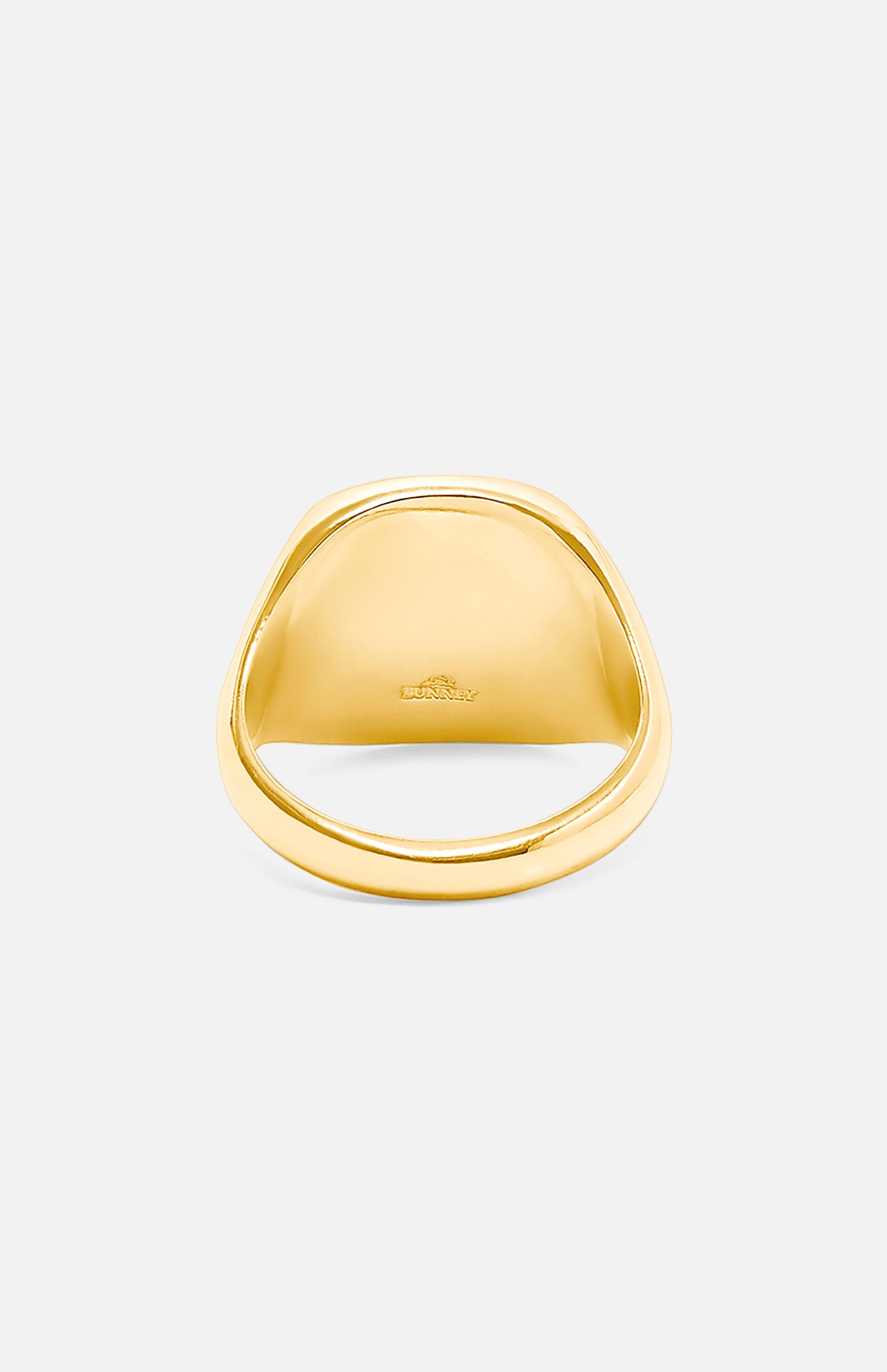 A close-up of the BUNNEY Mini Cushion Signet Ring in yellow gold, featuring a smooth, polished finish and an engraved logo inside the band, shown against a plain white background.