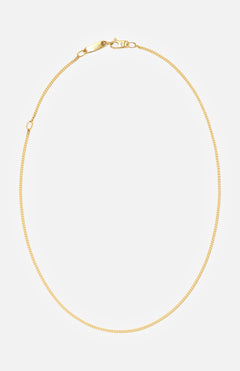 The BUNNEY Simple Chain Necklace 20" features a thin yellow gold design with a simple clasp, made in the UK and elegantly displayed in a circular form on a plain white background.