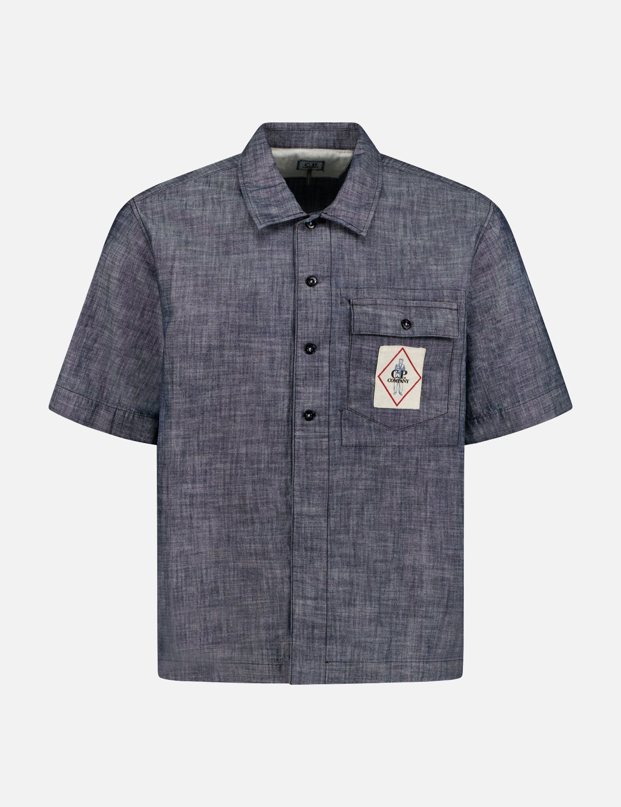 The C.P. COMPANY Chambray Logo-Pocket Short Sleeve Shirt features gray chambray-inspired cotton, a single chest pocket with a diamond logo patch, classic collar, and black buttons for a stylish finish.
