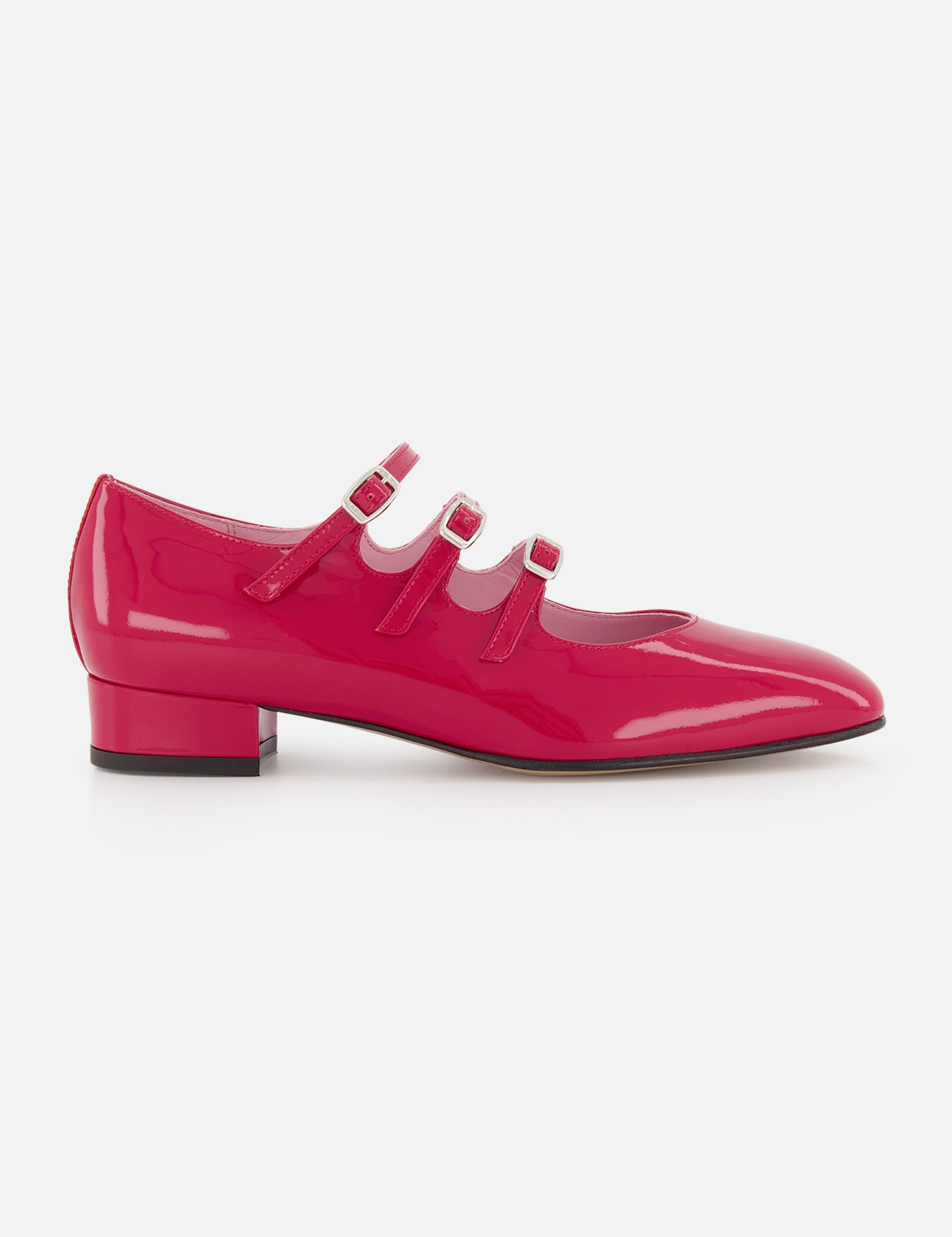 The Ariana Patent Leather Mary Jane Shoe by CAREL features a shiny bright pink finish, three thin straps, and a low block heel, shown here against a plain white background.