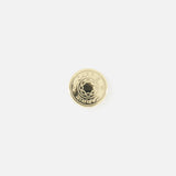 The CARRIE ATELIER Carrie Purse Hook in Yellow Gold is a round, shiny gold metal button engraved with "CARRIE," shown on a white background—ideal as a portable purse hanger or chic handbag hook.