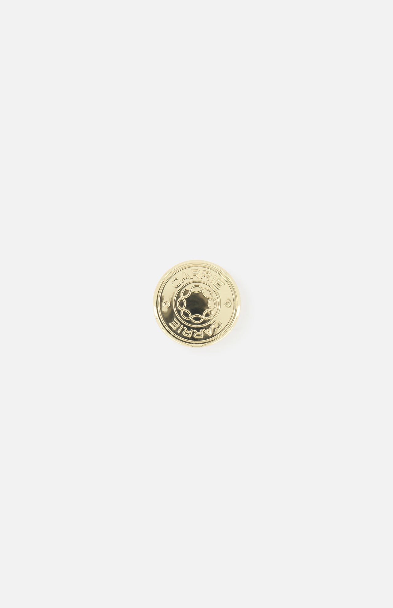 The CARRIE ATELIER Carrie Purse Hook in Yellow Gold is a round, shiny gold metal button engraved with "CARRIE," shown on a white background—ideal as a portable purse hanger or chic handbag hook.