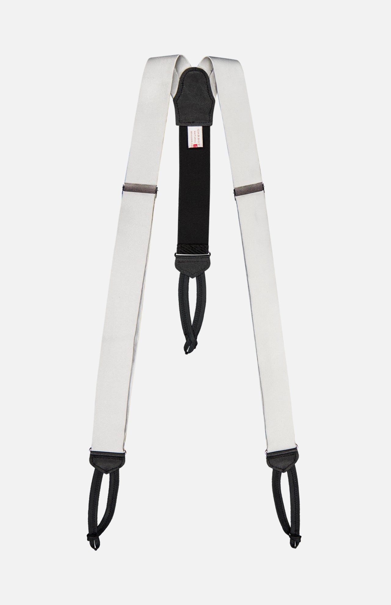 A white and black "Satin Suspenders" by CARROT & GIBBS, featuring adjustable sliders and looped ends inspired by handcrafted suspenders, shown against a plain white background.