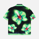 The CASABLANCA Glitch Orchid Cuban Collar Short Sleeve Shirt features a black base with vibrant green glitch floral patterns and red-centered flowers, adding bold energy to your button-up collection.