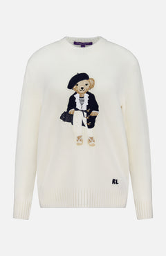 The Cashmere Bear Sweater from RALPH LAUREN COLLECTION is a white, nautical-inspired knit featuring an embroidered bear with a black bag and classic attire. Signature RL initials are stitched near the hem.