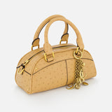 The CHLOÉ Ostrich-effect Bowling Hand Bag is a small, light tan bag with gold hardware, two handles, a zipper closure, and gold chain charms on one handle, shown against a white background.