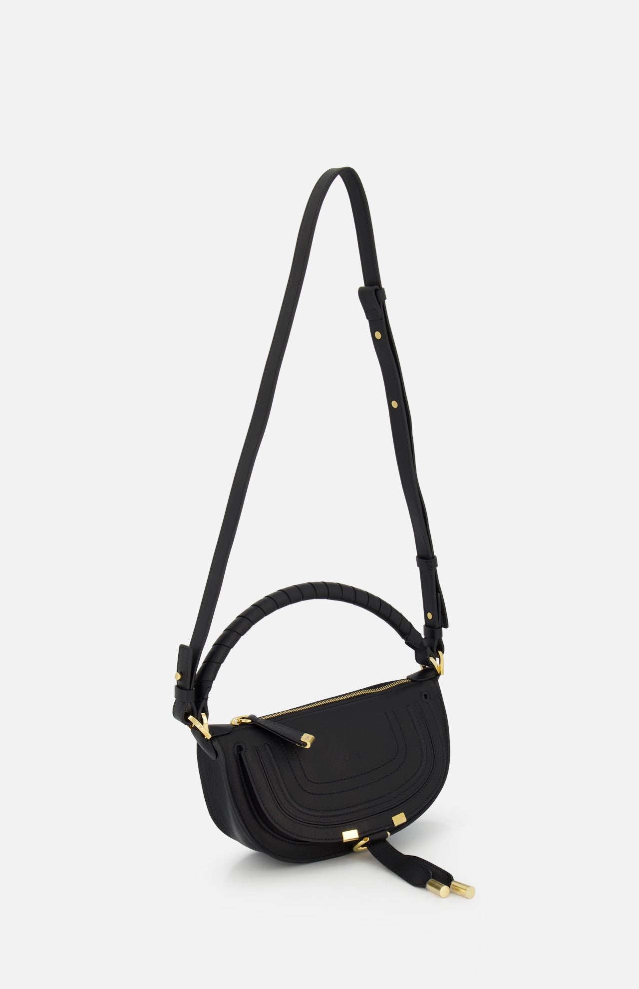 The CHLOÉ Marcie Mini Saddle Bag is a black leather crossbody with gold hardware, a curved flap, and an adjustable strap, shown against a plain white background.