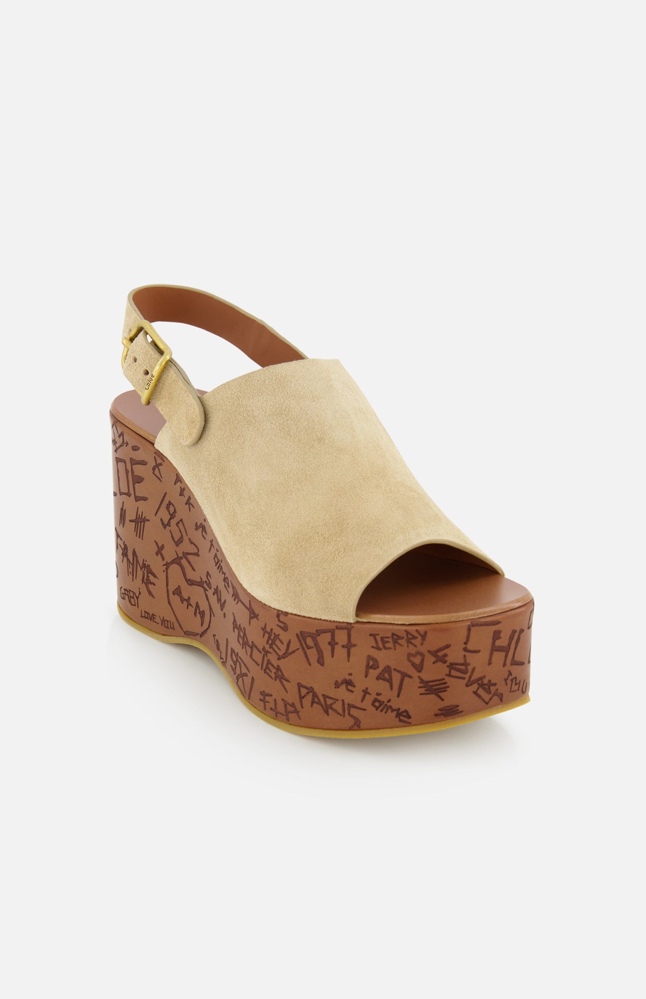 The Maxime Carved Wedge Heel by CHLOÉ is a tan suede platform sandal with an open toe, slingback strap, wood-effect wedge heel, graffiti-style thick brown sole, gold buckle, and is made in Italy.