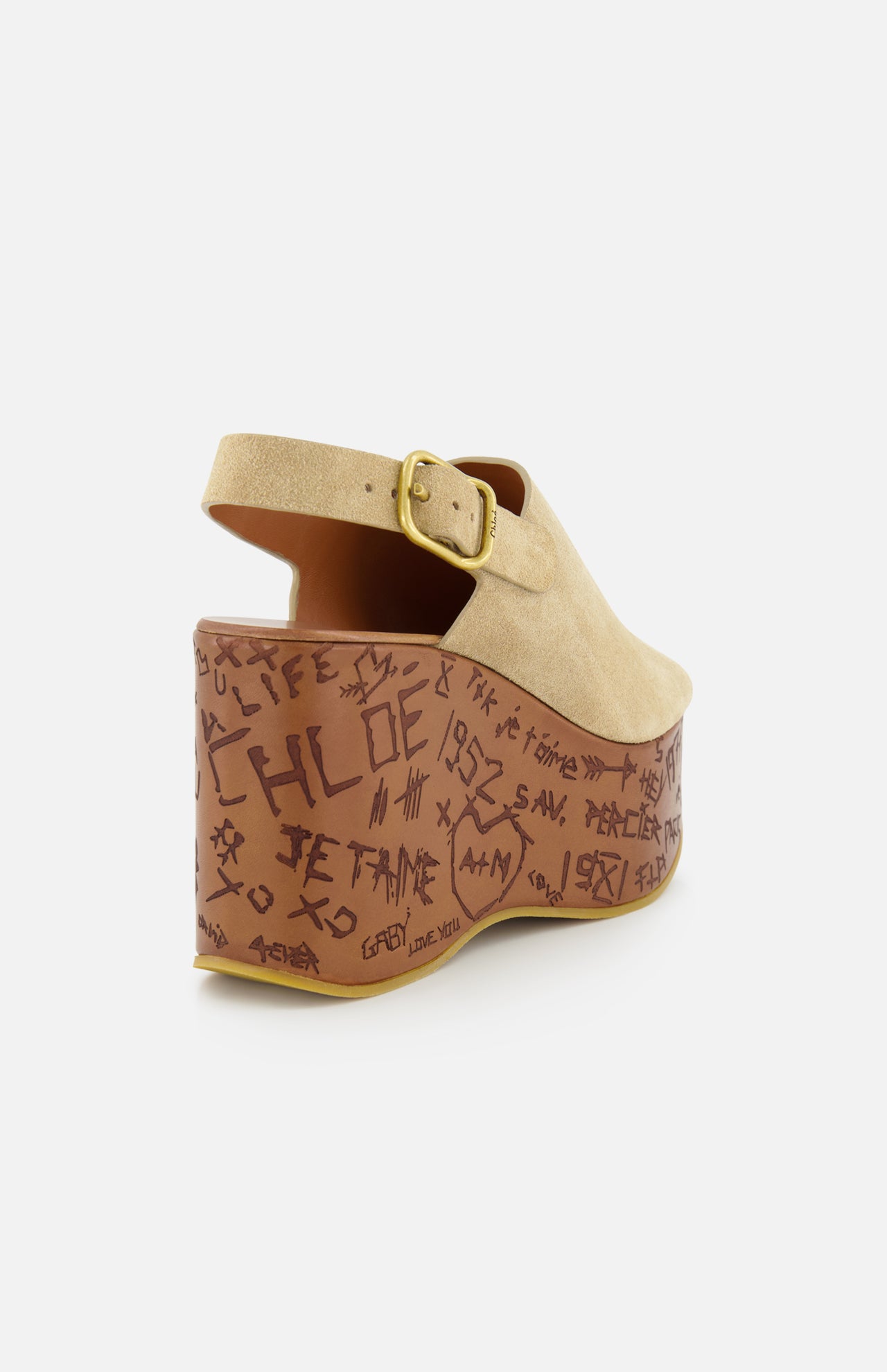 The CHLOÉ Maxime Carved Wedge Heel is a tan suede platform sandal with a buckle strap, thick brown sole, hand-drawn black graffiti-style details, and "CHLOE" text. Crafted from premium materials in Italy.