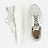 The image shows two CHLOÉ Metallized Nama Sneakers in light gray and white with thick, textured rubber soles—one displayed from above and the other from the side on a white background.