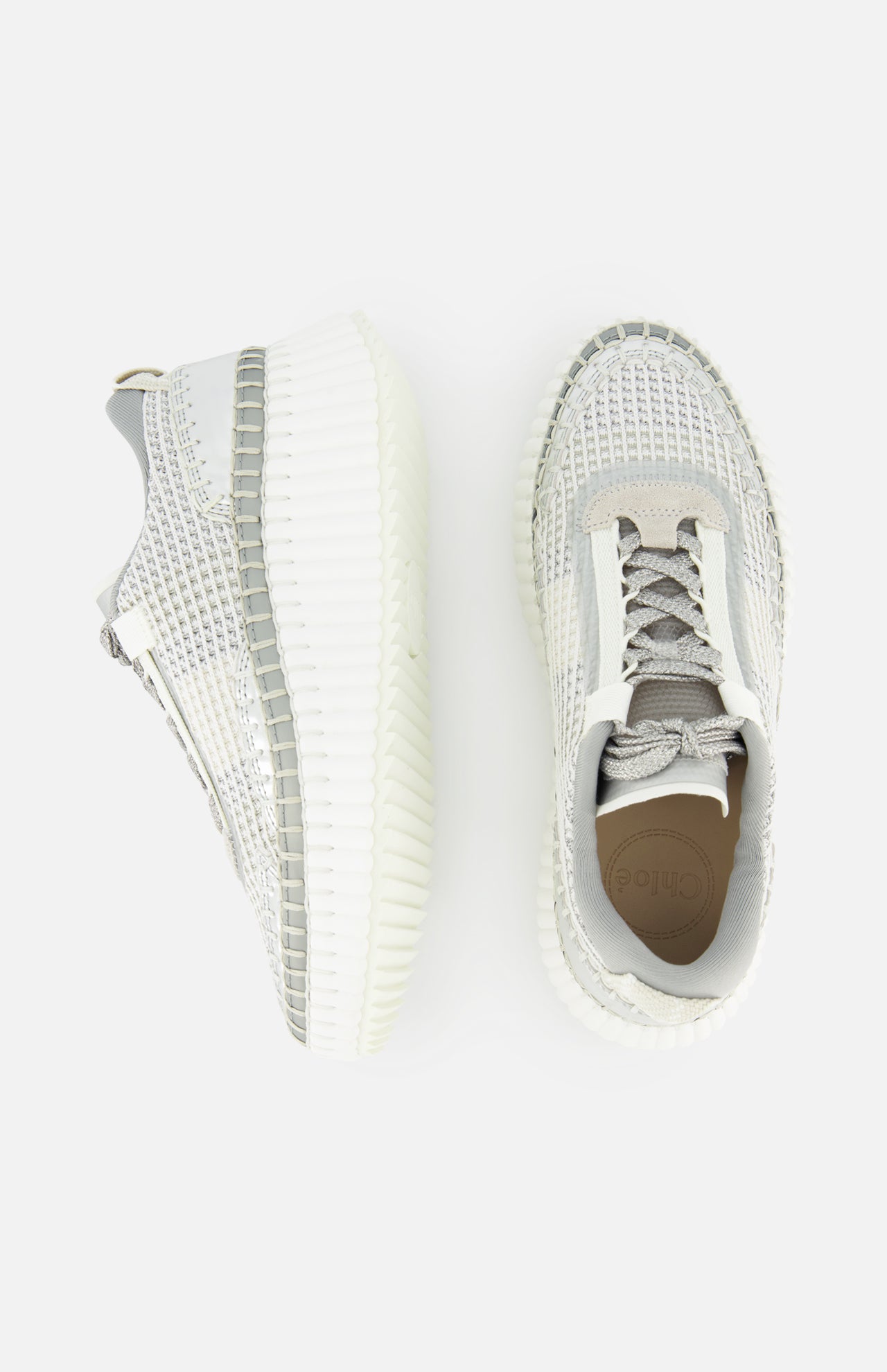 The image shows two CHLOÉ Metallized Nama Sneakers in light gray and white with thick, textured rubber soles—one displayed from above and the other from the side on a white background.