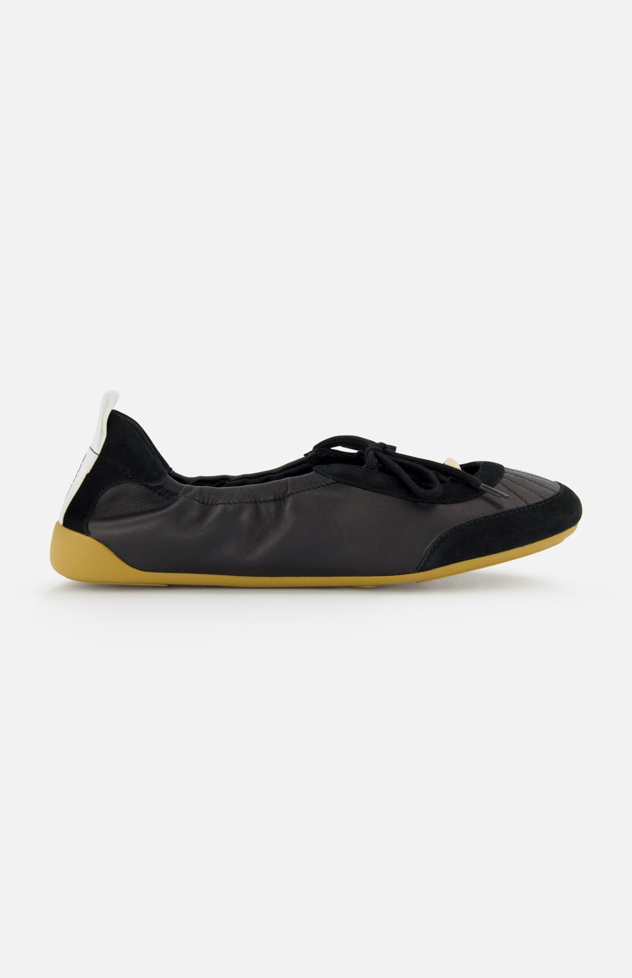The CHLOÉ Chloé Laced Kick Flats feature a black rounded toe, subtle textured detailing, black laces, a yellow-beige sole, and a white heel pull tab—sporty ballet shoes shown in profile on a white background.