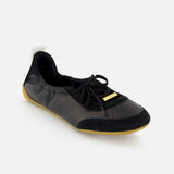 The CHLOÉ Laced Kick Flats are sporty black ballet shoes with laces, a suede toe cap, gold accents, a white heel pull tab, and a light brown rubber sole—an elegant addition to your flat collection.