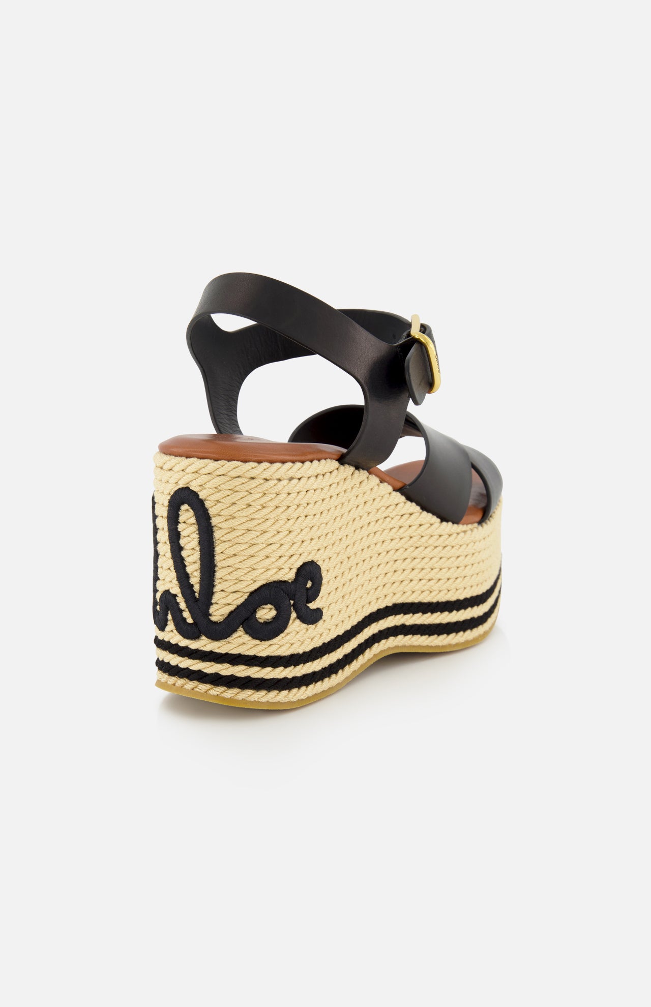 The CHLOÉ Chlóe Sand Wedge Heel features black leather straps, a gold buckle, a thick natural woven platform sole, and black embroidery spelling the Chloé logo on the heel.