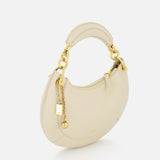 The Chloé Slim Banana Bag by CHLOÉ, crafted in Italy in a milk tone, features a curved shape, gold hardware, a leather top handle, and elegant gold chain accents, shown on a plain white background.