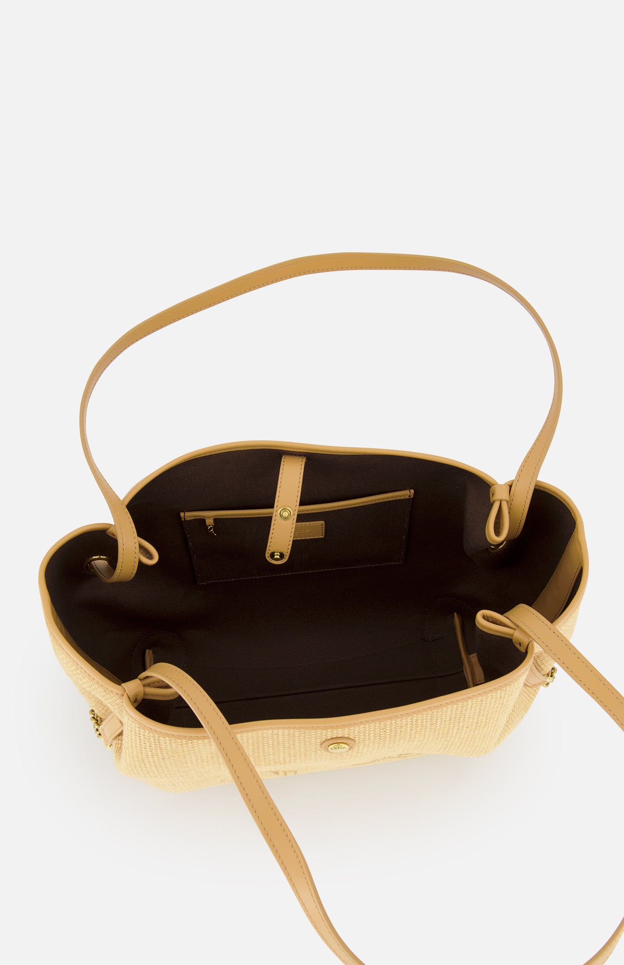 The CHLOÉ Raffia Clover Bag is a tan and beige woven raffia tote with leather trim, a brown interior lining, an inner zippered pocket, and an open compartment, shown from above.
