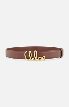 The Chloé Iconic Belt by CHLOÉ is a brown leather accessory with a gold buckle styled in the elegant cursive lettering of “Chloé,” showcased against a white background.