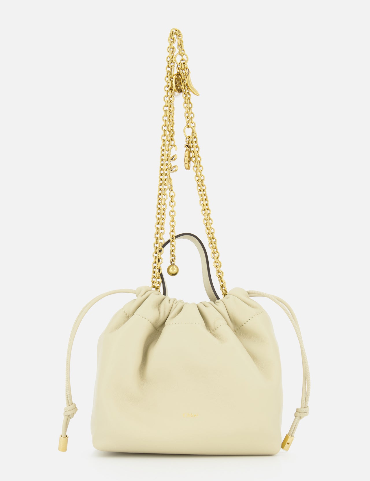 The CHLOÉ Chloé Icons Chain Strap Bag is a small cream leather handbag featuring slim side ties and a decorative gold chain handle embellished with charms, shown against a white background. This elegant mini shoulder bag exudes refined simplicity, echoing the timeless, effortless style characteristic of CHLOÉ.