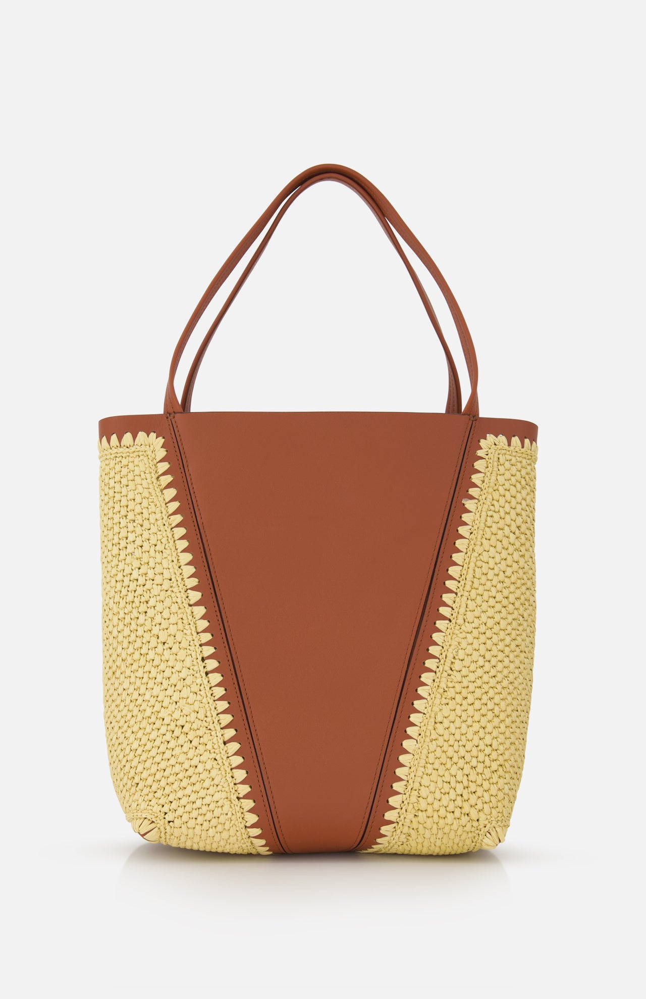 The CHLOÉ Woven Panels Spin Bag features tan leather center panels, raffia-inspired woven sides, double handles, and decorative edge stitching, all presented against a white background.