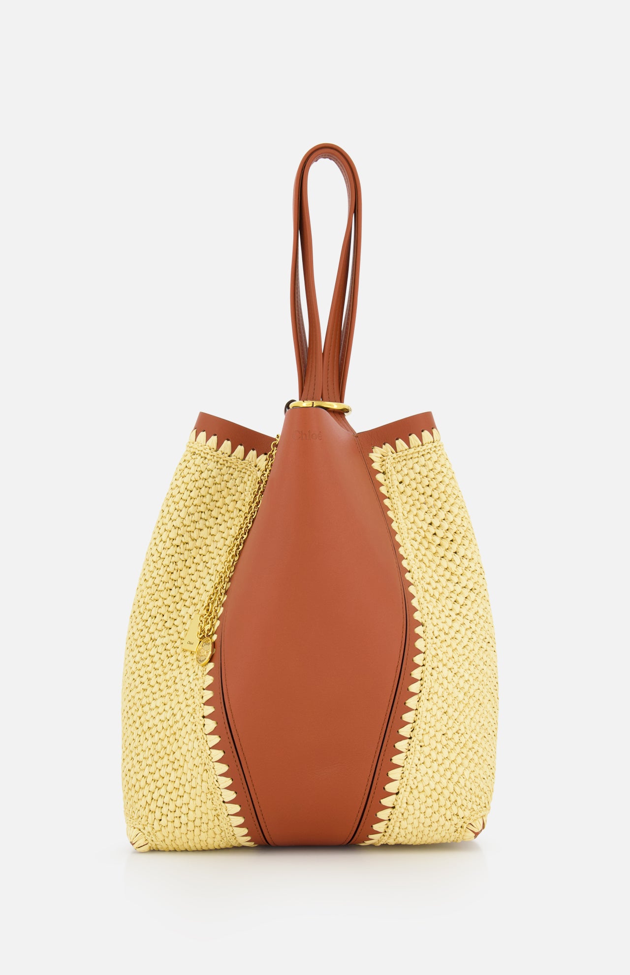 CHLOÉ's Chloé Woven Panels Spin Bag features a unique wrap-around design with double top handles, crafted in brown leather and raffia-inspired woven panels, displayed against a plain white background.