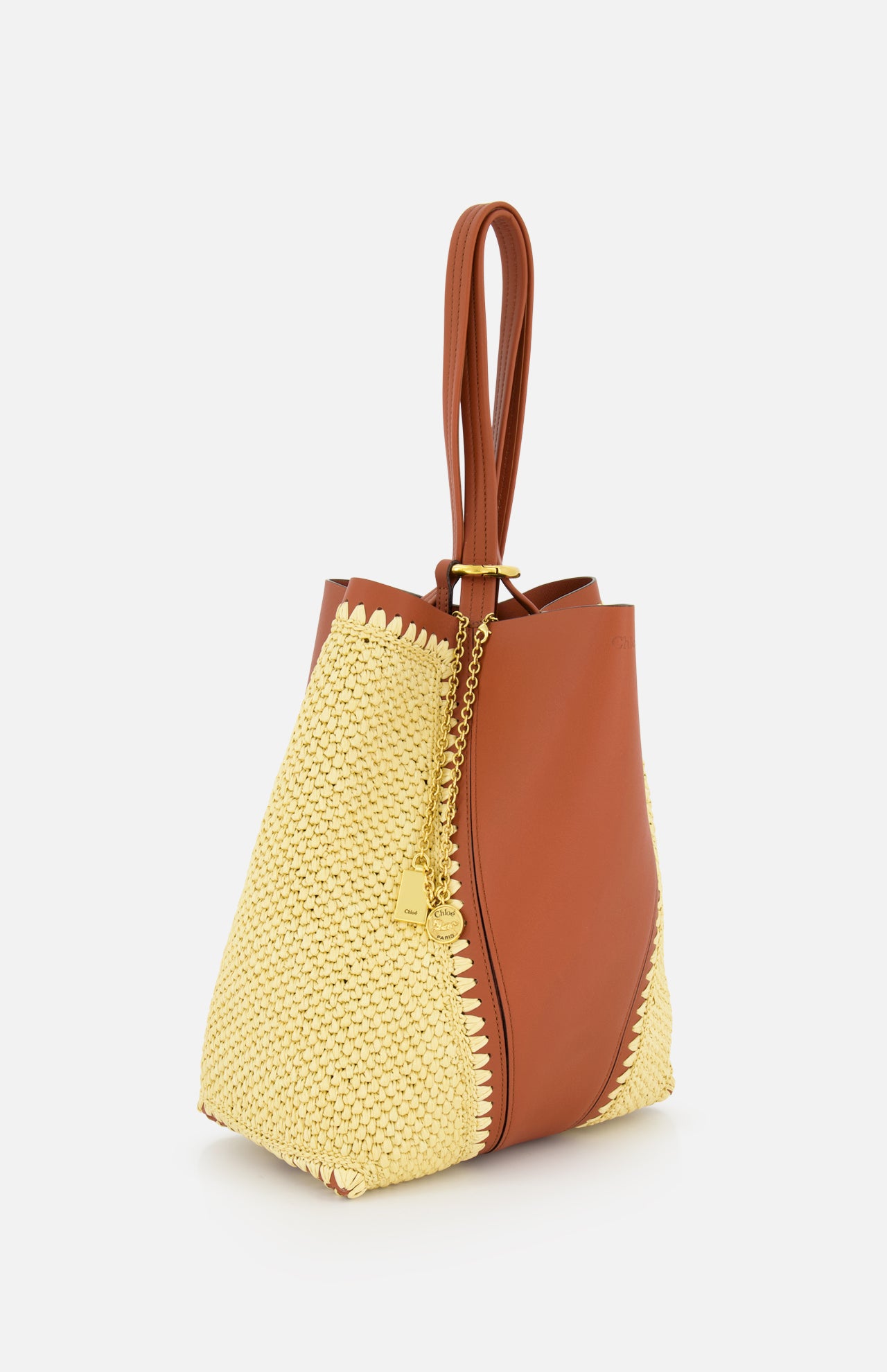 The CHLOÉ Woven Panels Spin Bag is a stylish bucket bag with brown leather panels, textured yellow woven sides, a gold chain with decorative charm, and double leather handles.
