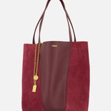 A CHLOÉ Leather and Suede Spin Bag in burgundy, featuring leather and suede panels, gold chain and padlock charm, double handles, and a removable bag chain for added versatility. Displayed against a plain white background.