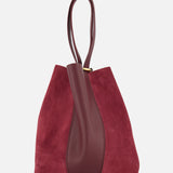 Displayed against a plain white background, the Chloé Leather and Suede Spin Bag by CHLOÉ features rich burgundy suede with a central dark red leather accent, matching leather handles, and includes a removable bag chain for added versatility.