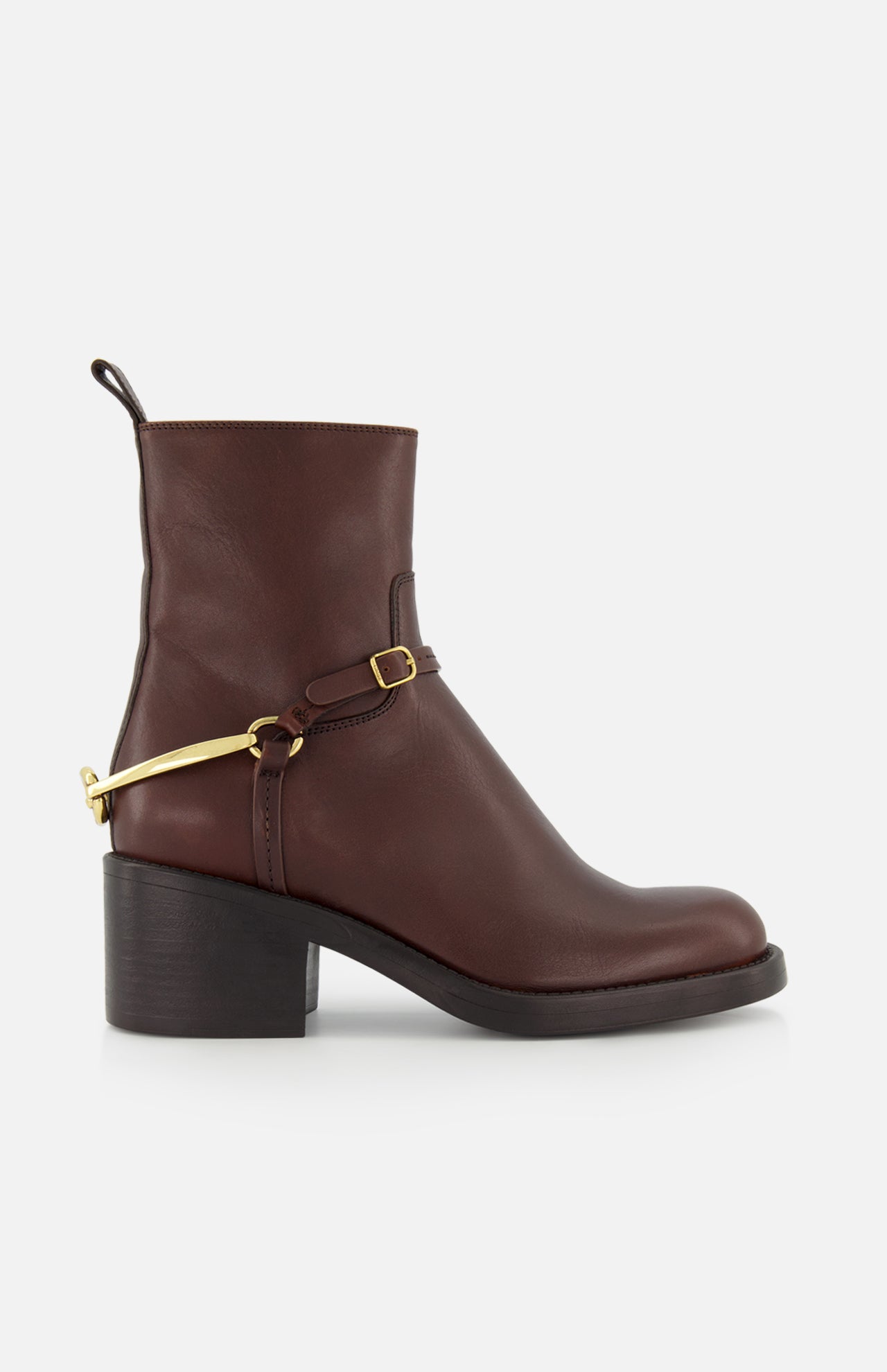 The CHLOÉ Dakota Riding Boot is a dark brown leather ankle boot with a chunky low heel, black sole, and gold metal harness detail—an equestrian-inspired style that adds a luxe touch to any outfit.
