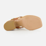 A close-up view of the sole of the CHLOÉ Janis Slingback Grommet Heels, highlighting its ginger brown leather, square toe design, and smooth light brown bottom against a white background.