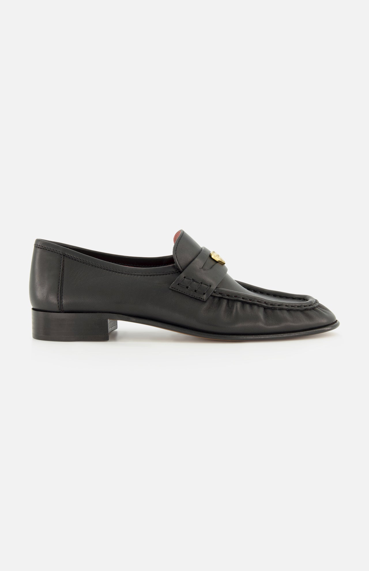 A pair of CHLOÉ Letti Gold Heart Loafers in black leather, featuring a low heel, moc toe stitching, and a signature gold-tone heart detail on the top—these feminine flats are pictured from the side against a white background, exemplifying the timeless elegance of classic Chloé design.