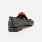 The CHLOÉ Letti Gold Heart Loafers feature black leather in a classic loafer silhouette, with a low heel. Viewed from the back and side, the shoe reveals a dark brown sole and a glimpse of its signature red interior lining.