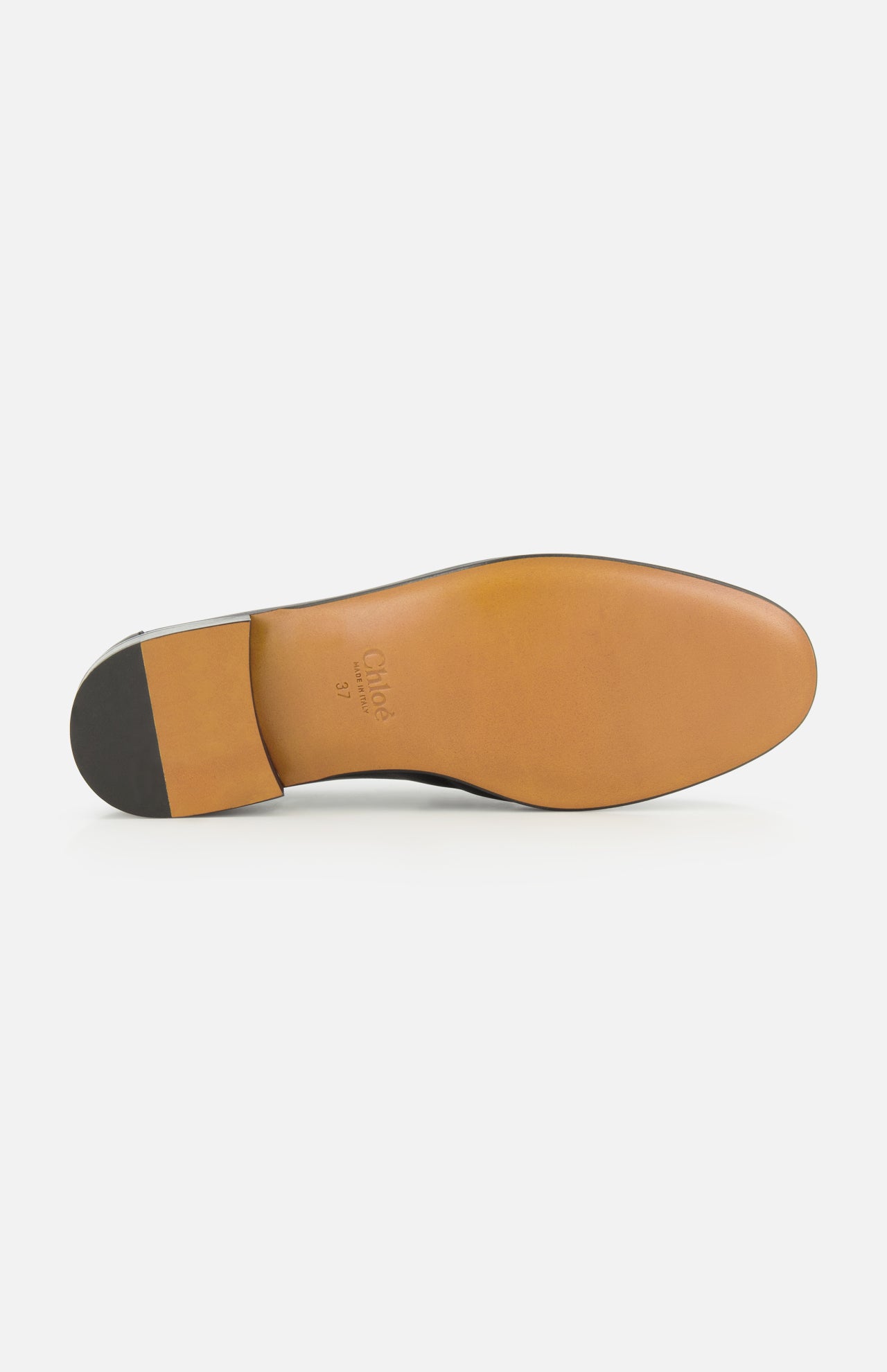 The image shows the sole of the CHLOÉ Letti Gold Heart Loafers, crafted in brown leather with a black heel. Near the arch, “CHLOÉ” and the size 37 are embossed, showcasing the brand’s signature attention to detail found in their feminine footwear.