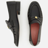 Two black Letti Gold Heart Loafers by CHLOÉ are displayed on a white background, with one shown from the side and the other from above. Each loafer features a gold-tone heart accent on the top, while the dark red insole bears the embossed CHLOÉ brand name. Combining classic style with luxurious detail, these loafers are an elegant choice for feminine flats.
