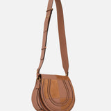 The CHLOE Marcie Bag, crafted in brown leather and suede with gold hardware, features a flap closure and adjustable shoulder strap. This chic statement saddle bag is displayed on a plain white background.