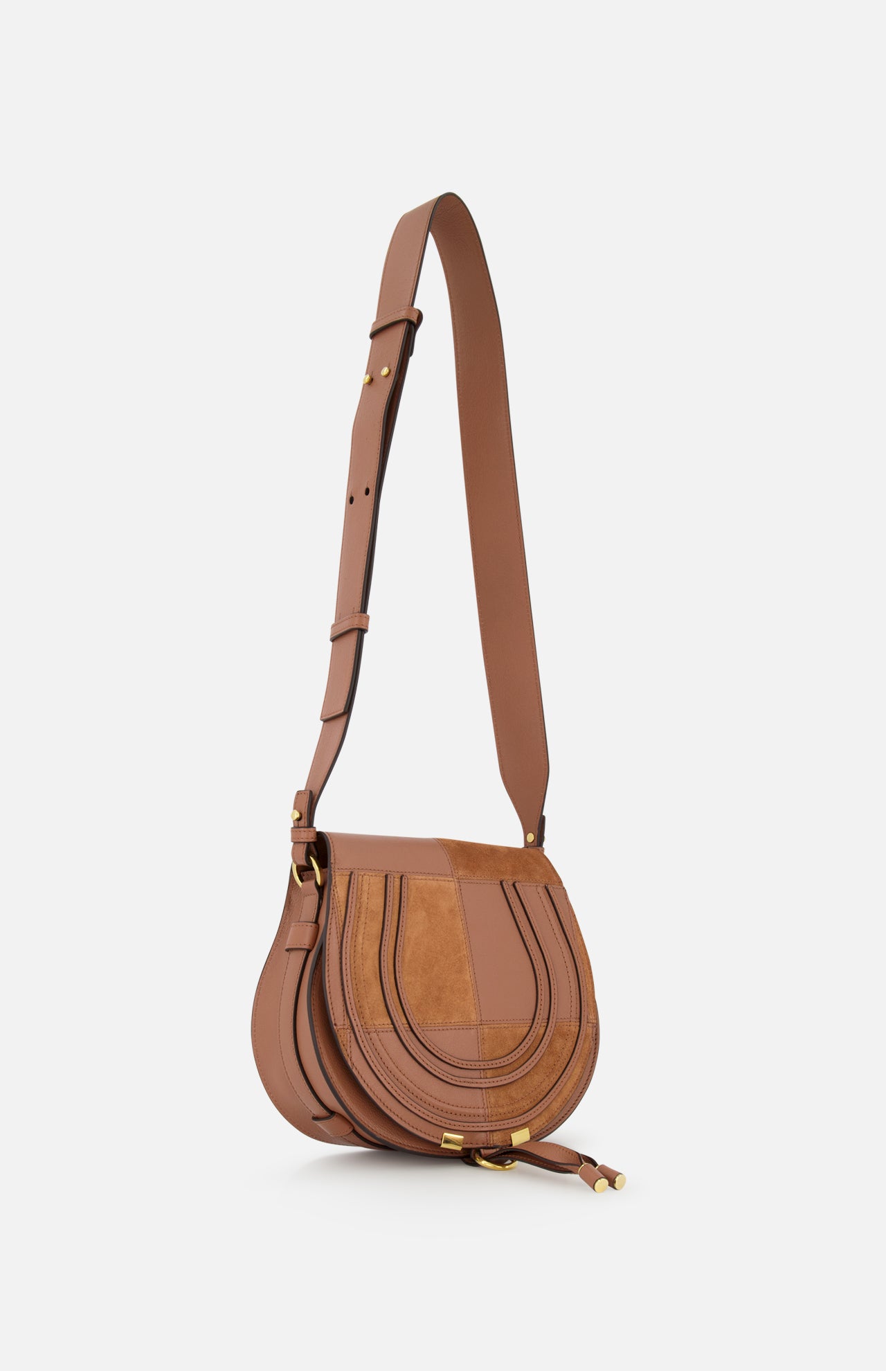 The CHLOE Marcie Bag, crafted in brown leather and suede with gold hardware, features a flap closure and adjustable shoulder strap. This chic statement saddle bag is displayed on a plain white background.