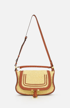 The Marcie Raffia Effect Shoulder Bag by CHLOÉ features brown leather accents, a flap closure, decorative stitching, and a long adjustable strap, shown against a plain white background.